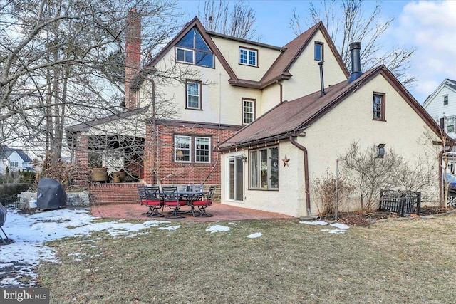 snow covered property featuring a yard and a patio area