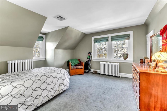 carpeted bedroom with radiator heating unit and vaulted ceiling