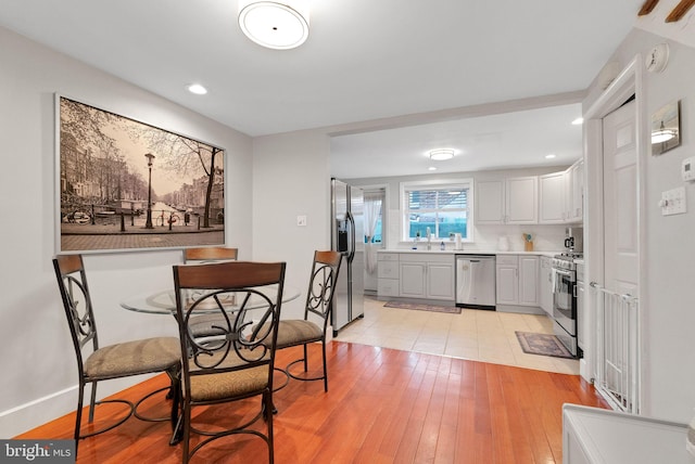 dining space with sink and light wood-type flooring