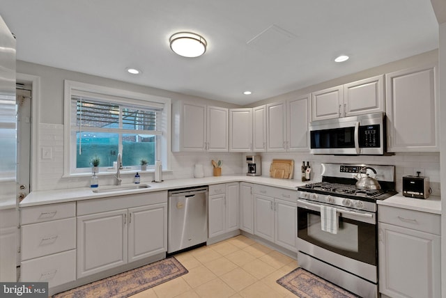 kitchen featuring sink, light tile patterned floors, decorative backsplash, and appliances with stainless steel finishes