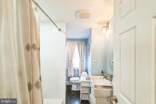 bathroom featuring vanity, curtained shower, and toilet