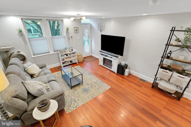 living room featuring an inviting chandelier and hardwood / wood-style floors