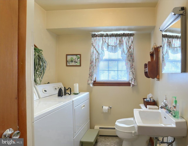 interior space featuring sink, a baseboard radiator, and washing machine and clothes dryer