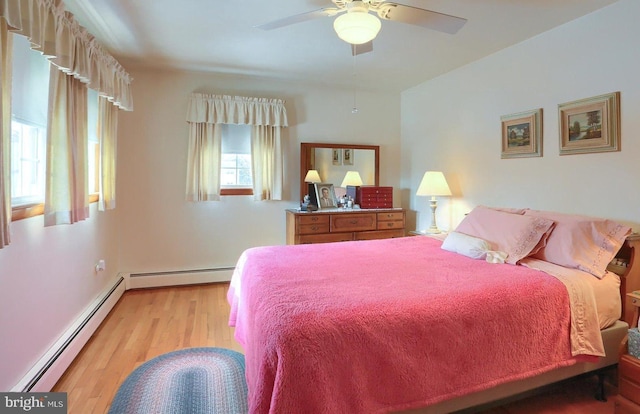 bedroom featuring a baseboard heating unit, light hardwood / wood-style floors, and ceiling fan