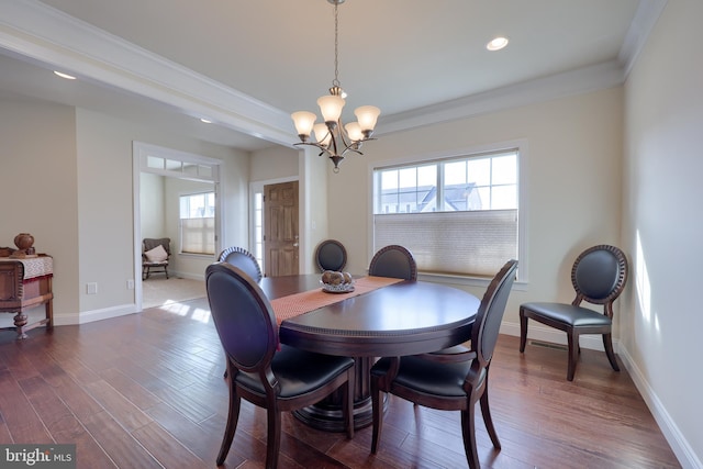 dining space with ornamental molding, dark wood-type flooring, and a notable chandelier