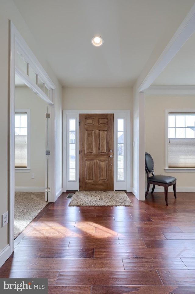 foyer with a healthy amount of sunlight and dark hardwood / wood-style floors