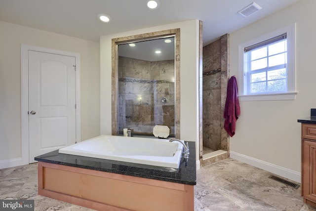 bathroom with vanity and shower with separate bathtub