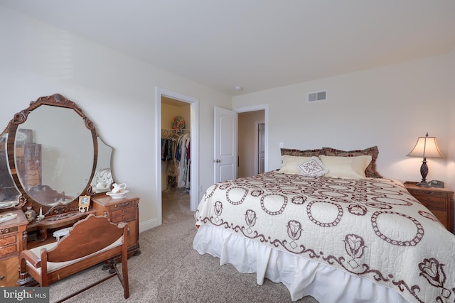 bedroom featuring a closet, a spacious closet, and light carpet