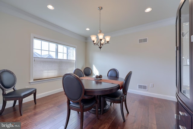 dining room featuring ornamental molding, dark hardwood / wood-style flooring, and a chandelier