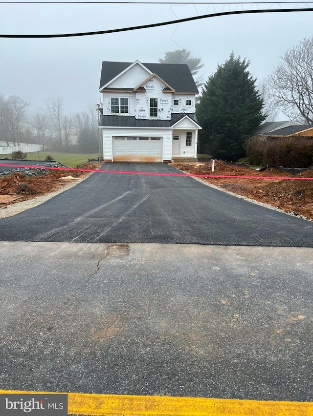 view of front facade with a garage and aphalt driveway