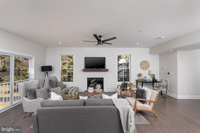 living area with dark wood-type flooring, a fireplace, recessed lighting, and baseboards