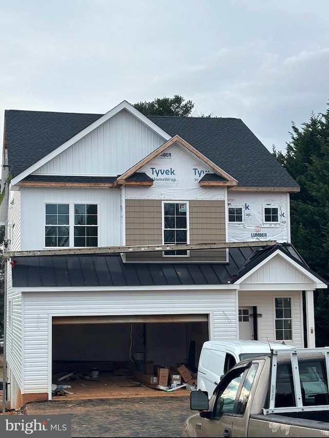 view of front of property with an attached garage, a standing seam roof, metal roof, and decorative driveway