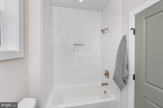 bathroom featuring shower / bathing tub combination and toilet