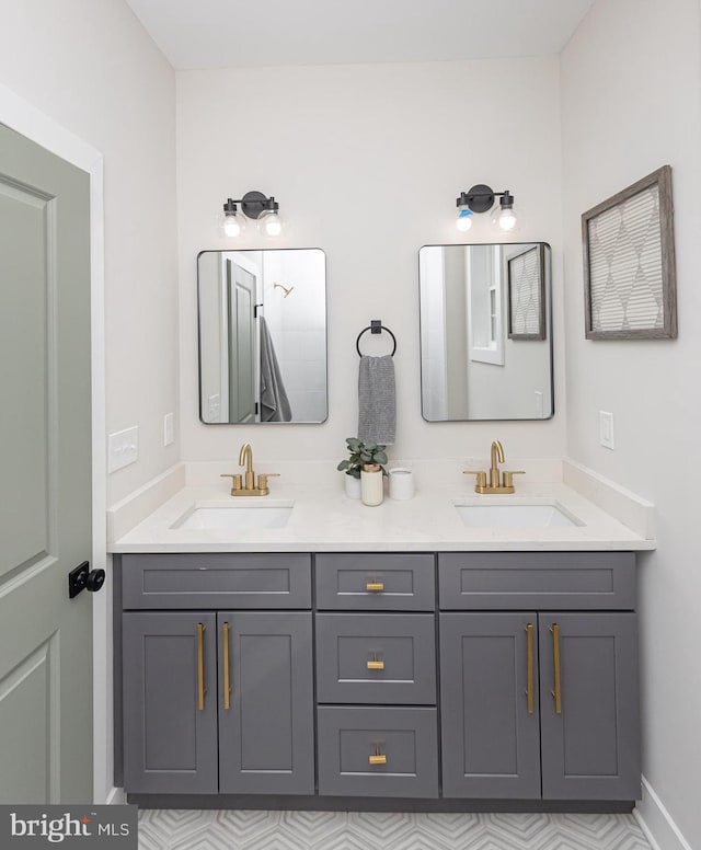 full bathroom featuring double vanity, a sink, and baseboards