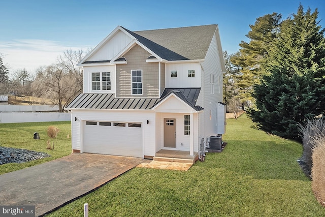 view of front of house featuring a garage, driveway, a front lawn, and a standing seam roof