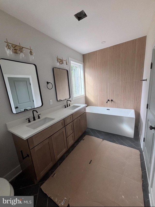 bathroom with double vanity, a soaking tub, tile patterned flooring, and a sink