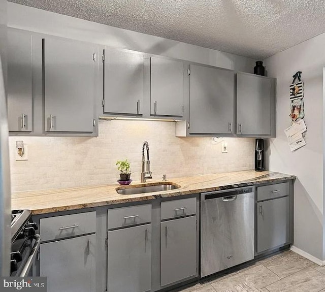 kitchen featuring sink, gray cabinetry, tasteful backsplash, a textured ceiling, and appliances with stainless steel finishes