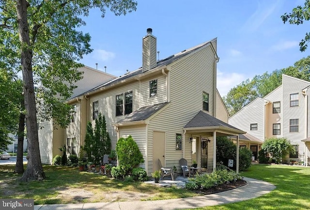 back of house featuring a patio area and a lawn