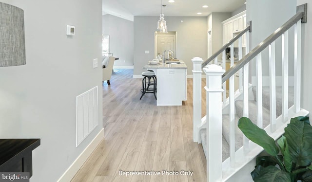 hallway featuring sink and light wood-type flooring