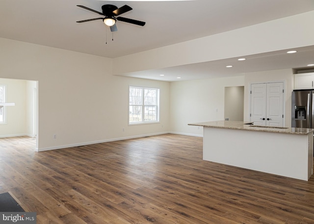 unfurnished living room with ceiling fan and dark hardwood / wood-style flooring