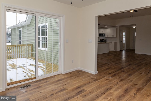 unfurnished room with dark wood-type flooring and ceiling fan