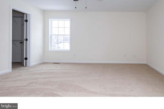 spare room with light carpet and ceiling fan