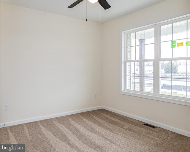 carpeted empty room featuring a healthy amount of sunlight and ceiling fan