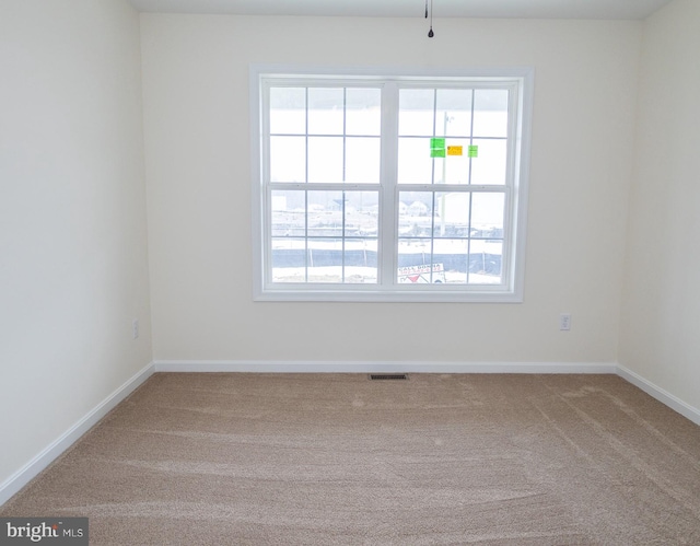 unfurnished room featuring plenty of natural light and carpet flooring