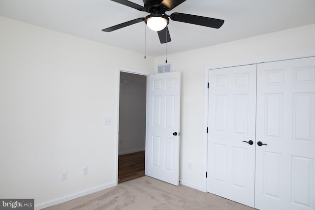 unfurnished bedroom with ceiling fan, a closet, and light carpet