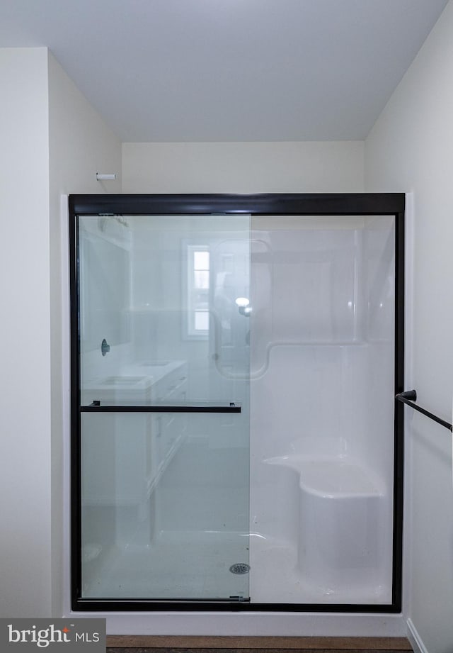 bathroom featuring a shower with door