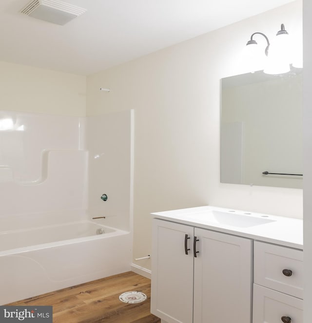 bathroom with wood-type flooring, bathtub / shower combination, and vanity