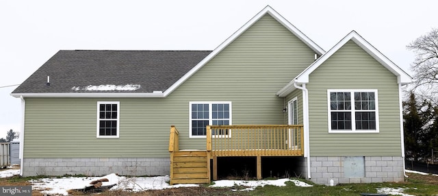 snow covered rear of property featuring a deck