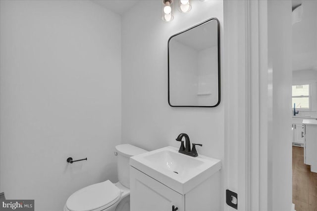 bathroom with hardwood / wood-style flooring, vanity, and toilet