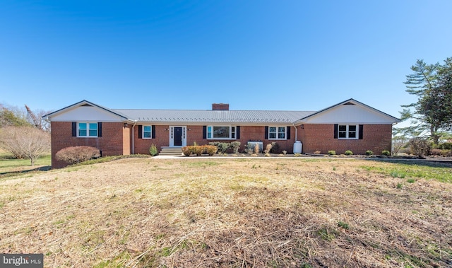 single story home featuring a front lawn, brick siding, and a chimney
