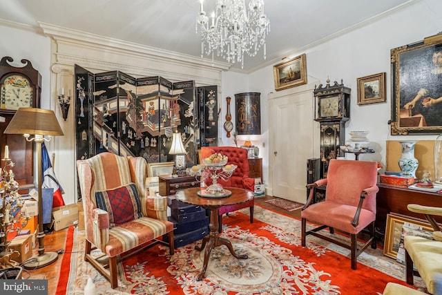 living area with an inviting chandelier, crown molding, and hardwood / wood-style flooring