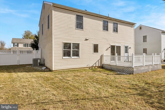 back of property with central AC unit, a deck, and a lawn