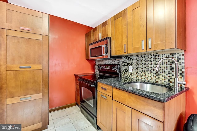 kitchen featuring light tile patterned flooring, tasteful backsplash, black electric range oven, sink, and dark stone counters