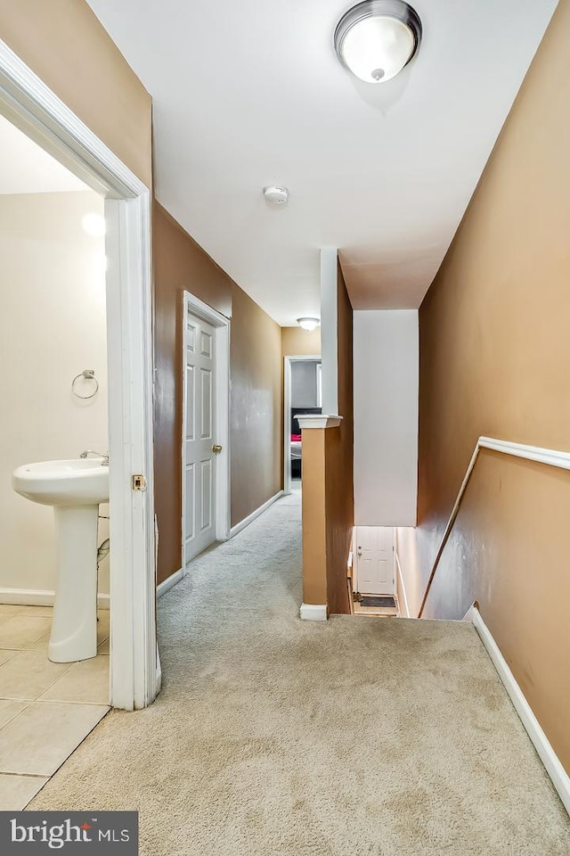 corridor featuring sink and carpet flooring