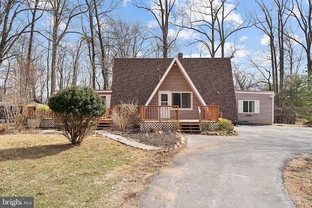 a-frame home featuring roof with shingles, driveway, a chimney, and a wooden deck