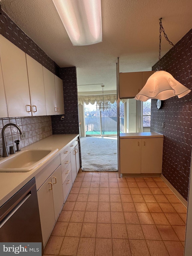 kitchen featuring a healthy amount of sunlight, pendant lighting, sink, and stainless steel dishwasher