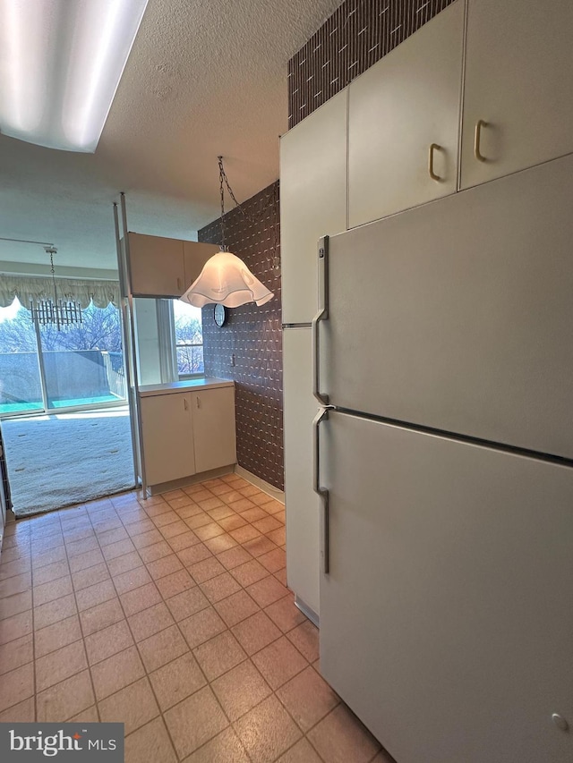 kitchen featuring white refrigerator and decorative light fixtures