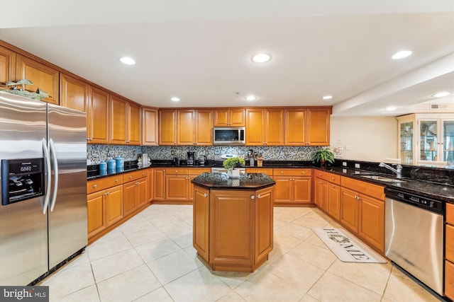 kitchen featuring sink, light tile patterned floors, dark stone countertops, a kitchen island, and stainless steel appliances