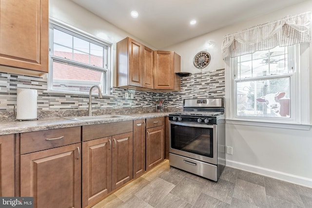 kitchen featuring gas range, sink, and decorative backsplash