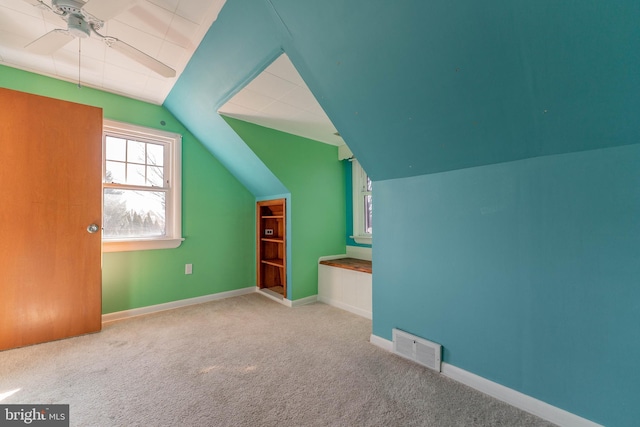 bonus room featuring lofted ceiling, light carpet, and ceiling fan