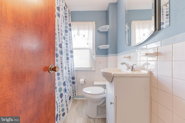 bathroom featuring vanity, toilet, tile walls, and a shower with shower curtain