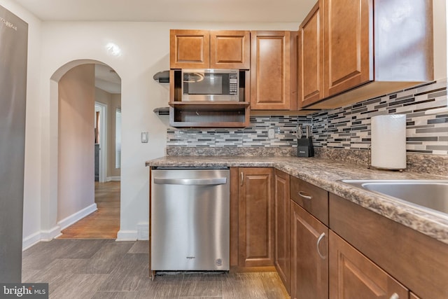 kitchen with stainless steel appliances, dark hardwood / wood-style floors, and decorative backsplash