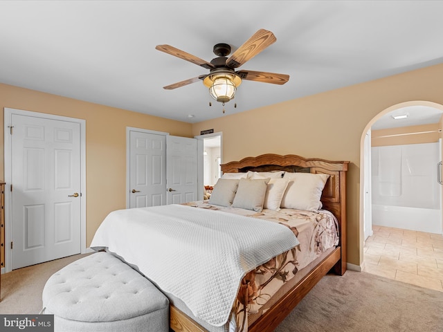 carpeted bedroom featuring ceiling fan and ensuite bathroom