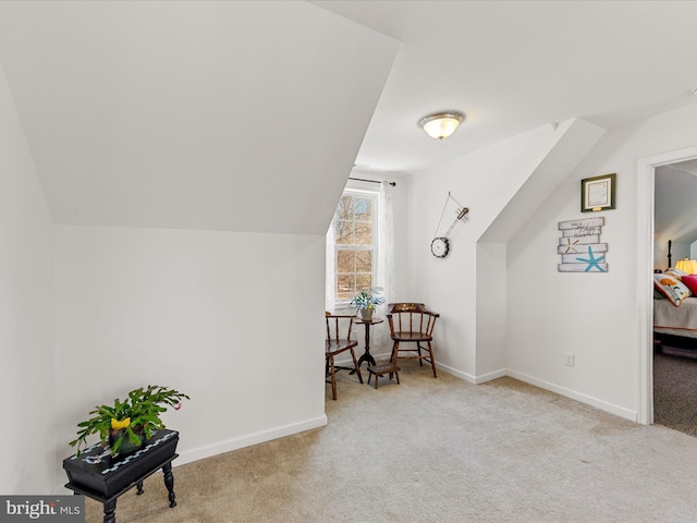 additional living space featuring vaulted ceiling and light carpet