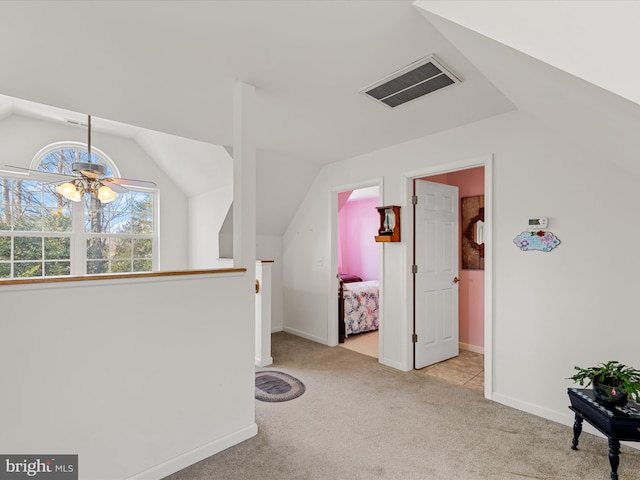 corridor featuring lofted ceiling and light colored carpet