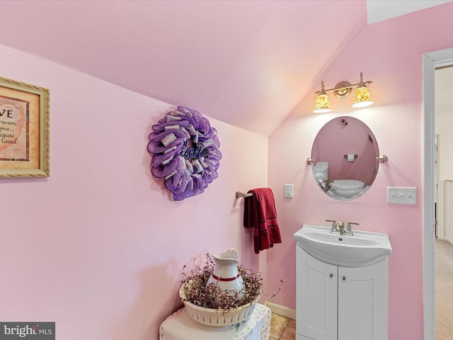 bathroom with tile patterned floors, vanity, and vaulted ceiling